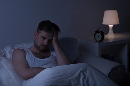 Man suffering from sleeplessness due to a bed bug infestation